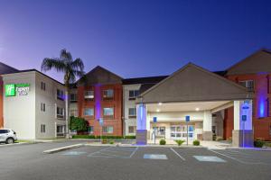 图莱里Holiday Inn Express & Suites - Tulare by IHG的一家前面有停车场的酒店