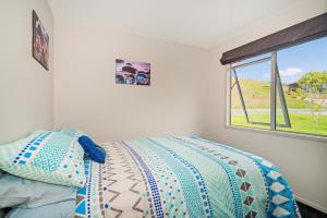 Un pat sau paturi într-o cameră la The Blue Rendevous - Whangamata Holiday Home