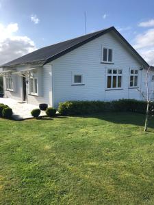 una casa blanca con un patio delante en Ataahua Homestay, en Feilding