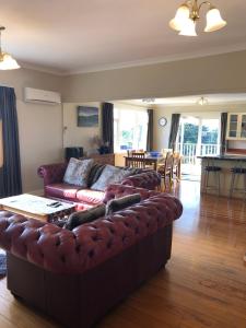 a living room with a leather couch and a table at Ataahua Homestay in Feilding