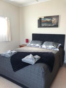 a bedroom with a large bed with two towels on it at Ataahua Homestay in Feilding