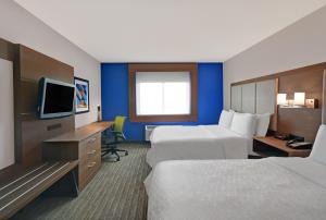 a hotel room with two beds and a television at Holiday Inn Express Marshall, an IHG Hotel in Marshall