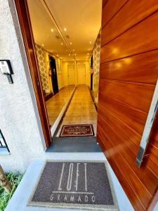 an entrance to a house with a welcome mat on the door at Loft Gramado in Gramado