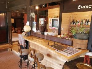 un bar in un ristorante con bancone e sgabelli di Guesthouse Kazura a Nanto