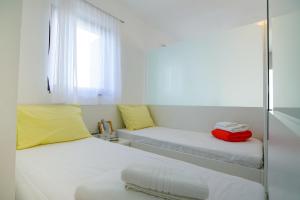 a room with two beds with yellow and red luggage at Apartments Secret Garden in Ražanac
