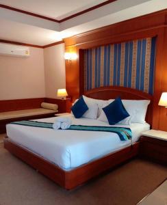 Un dormitorio con una cama grande con almohadas azules. en The Lion King Hotel Udonthani, en Udon Thani 35 fotos más