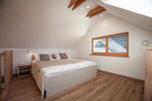 Habitación blanca con cama y ventana en Apartments Izvir en Bohinj