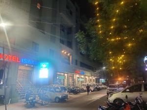 a city street at night with cars parked on the street at Hotel Aishwaryaa in Erode