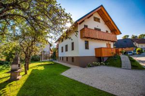 a large white house with a wooden roof at Apartments Izvir in Bohinj