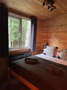 een slaapkamer met een groot bed in een houten hut bij Percy Wood Lodges with Hot Tubs in Swarland