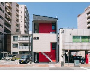 um edifício vermelho e branco numa cidade com carros em REQRAS Sakuramachi - Vacation STAY 52733v em Kumamoto