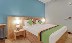um quarto com uma grande cama branca com almofadas verdes em Itsy By Treebo - Classio Richmond em Bangalore