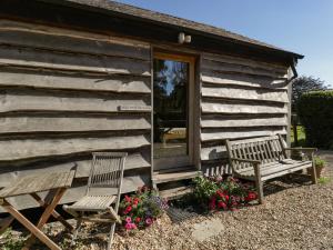 two chairs sitting outside of a log cabin at The Little Granary in Fordingbridge