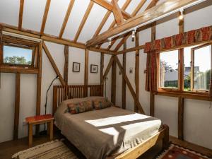 a bedroom with a bed in a room with windows at The Little Granary in Fordingbridge