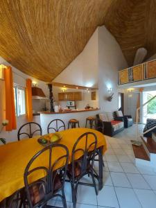 a kitchen and living room with a yellow table and chairs at Villa Teranga Saly Sénégal in Saly Portudal