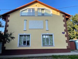 uma casa com três janelas do lado em У Поттера em Kalichanka