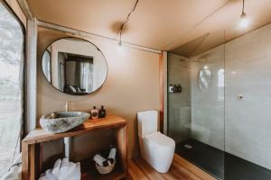 a bathroom with a sink and a toilet and a mirror at Evamor Valley in Mudgee