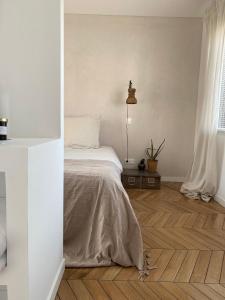 Wailly-BeaucampにあるCasa louisa chambre sauna et bain nordiqueの白いウッドフロアのベッドルーム(ベッド1台付) +7枚の写真