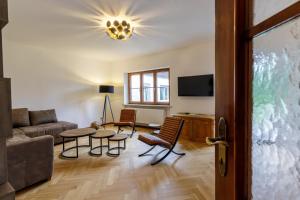 a living room with a couch and a table and chairs at Stadtvilla Falkenstein in Füssen