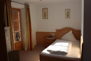 ein kleines Schlafzimmer mit einem Bett und einem Fenster in der Unterkunft Gasthaus Aiplspitz in Bayrischzell
