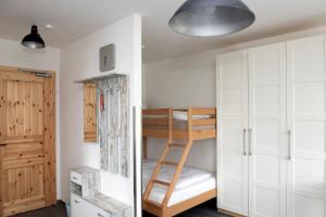 a bedroom with a bunk bed and a ladder at Pension Biohof Klügel in Freital