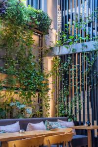 a patio with a couch and tables and plants at Sigma59 Dine & Stay in Hersonissos