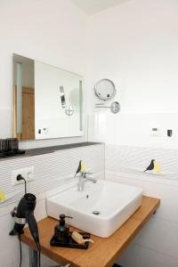 y baño con lavabo blanco y espejo. en Pension Biohof Klügel, en Freital