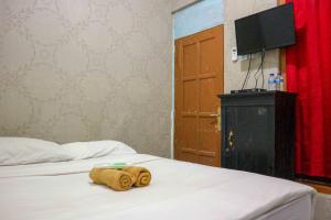 a hotel room with a bed with a towel on it at Monjali Inn RedPartner near Tugu Yogyakarta in Jetis