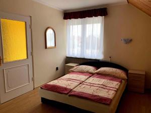 een slaapkamer met een bed voor een raam bij Apartment in Balatonlelle 19129 in Balatonlelle