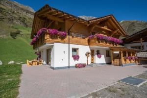a house in the mountains with purple flowers at Fewo Sonnenaufgang - Zeppichl in Pfelders