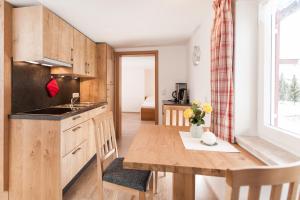 a kitchen with wooden cabinets and a wooden table at Landhaus Tannheimer in Oberstdorf