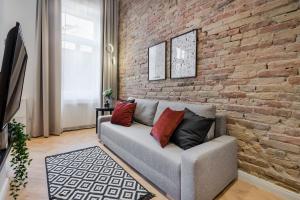 sala de estar con pared de ladrillo y sofá en K33- Boutique Apartments, Best Location, by BQA en Budapest