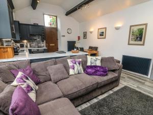 a living room with a brown couch with purple pillows at The Lodge in Ulverston