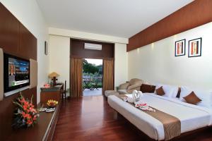 a hotel room with a large bed and a television at Silent Shores Resort & Spa in Mysore