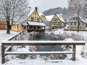 eine Bank im Schnee neben einem Fluss in der Unterkunft Ferienwohnung Koppelblick in Pfarrweisach