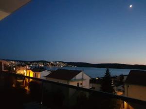 een balkon met uitzicht op de stad 's nachts bij Apartmani Manuela in Okrug Gornji