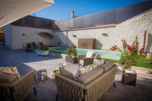 een patio met banken en een zwembad in een gebouw bij Los Tinajones in Colmenar de Oreja