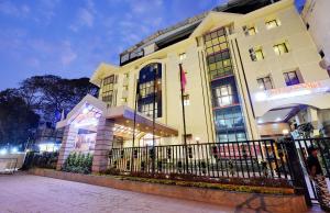 a building with a fence in front of it at Manpho Bell Hotel & Convention Center in Bangalore