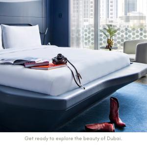 a bedroom with a large white bed with red shoes at ME Dubai by Meliá in Dubai