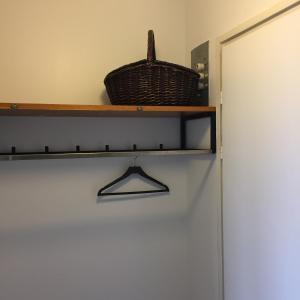 une étagère à côté d'une porte avec un panier dans l'établissement Kumpukuja apartment, à Kouvola