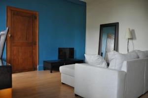 een woonkamer met een witte bank en een televisie bij agréable duplex Candé centre ville 4/6 places in Candé