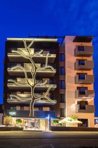 a building with a tree on the side of it at Aparthotel NOX in Cluj-Napoca