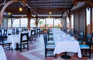 a dining room with white tables and chairs at Charmillion Sea Life Resort in Sharm El Sheikh