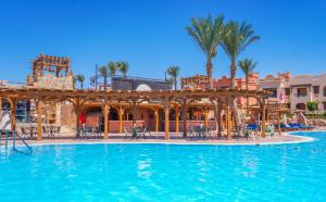 a pool at a resort with tables and chairs at Charmillion Sea Life Resort in Sharm El Sheikh