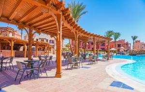 a patio with tables and chairs next to a swimming pool at Charmillion Sea Life Resort in Sharm El Sheikh +21 photos