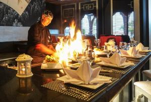 a man standing behind a table with plates of food at Charmillion Sea Life Resort in Sharm El Sheikh