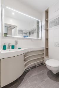 a white bathroom with a toilet and a sink at The Brucklyn Apartments in Erlangen