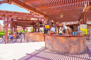 an outdoor bar with a wooden pergola at Charmillion Sea Life Resort in Sharm El Sheikh