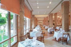 a restaurant with white tables and chairs and windows at Charmillion Sea Life Resort in Sharm El Sheikh