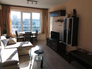 - un salon avec un canapé, une télévision et une table dans l'établissement Апартамент Зорница, à Bourgas